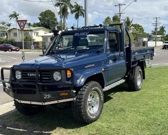 Dark Blue Toyota Land Cruiser Pickup Truck Parked on Grass — Aitkenvale Exhausts & Towbars Pty Ltd In Aitkenvale, QLD