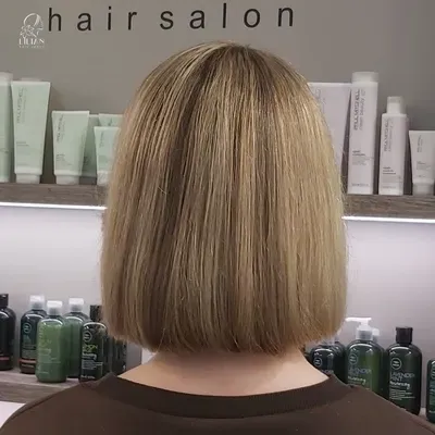 Gezeigt wird der Hinterkopf einer Frau in einem Friseursalon.