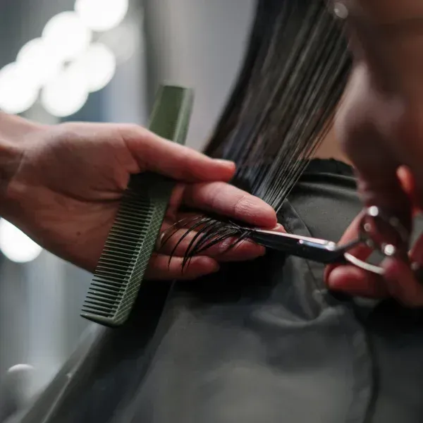 Eine Frau lässt sich beim Friseur die Haare schneiden