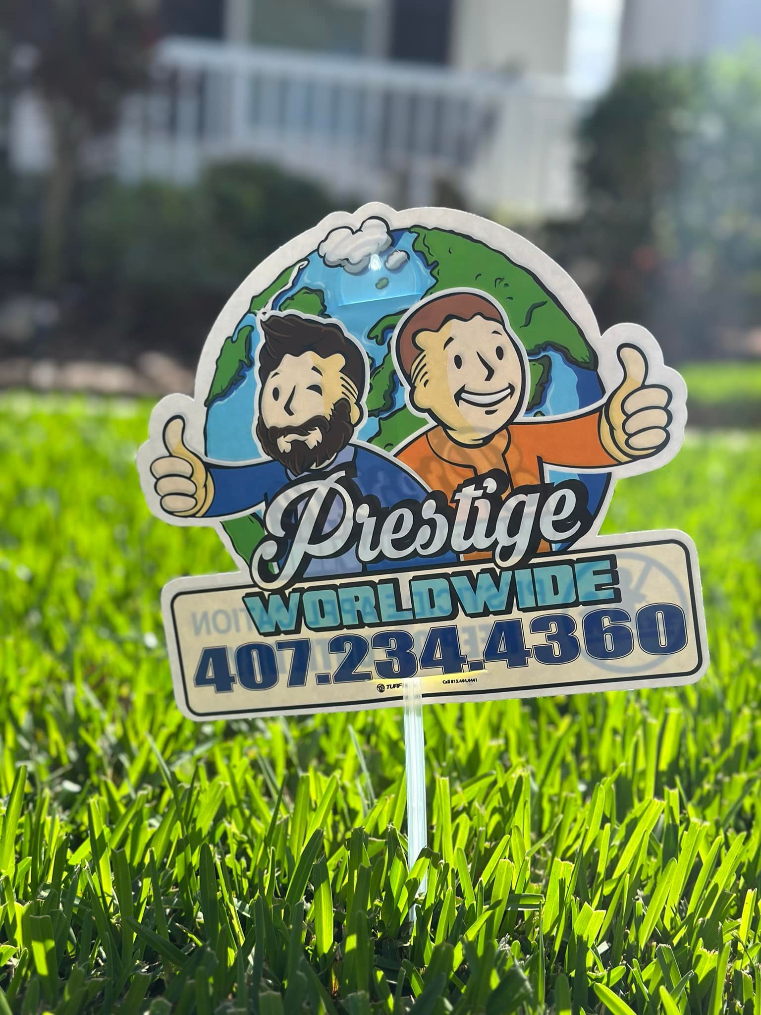 Prestige Worldwide lawn sign with two cartoon men and a phone number in a grassy yard