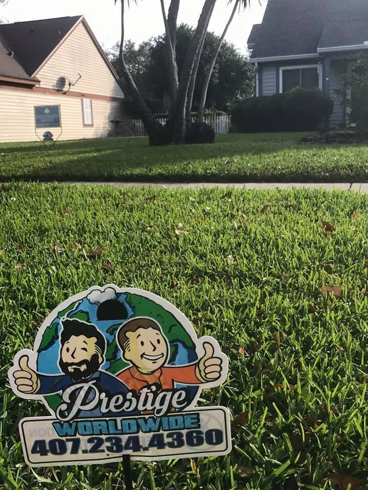 Prestige Power Washing yard sign on green lawn with houses in the background