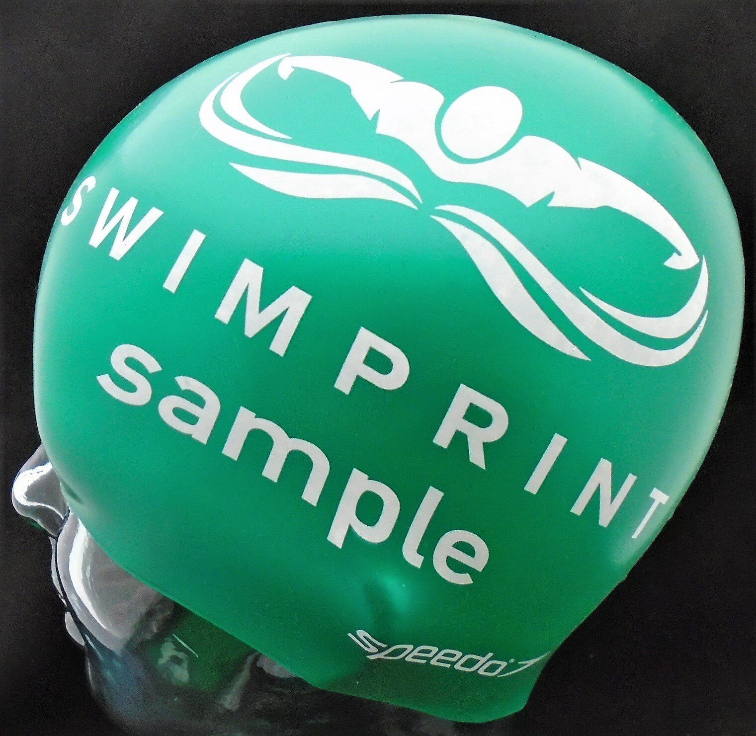 A green swim cap that says ' swim print sample ' on it