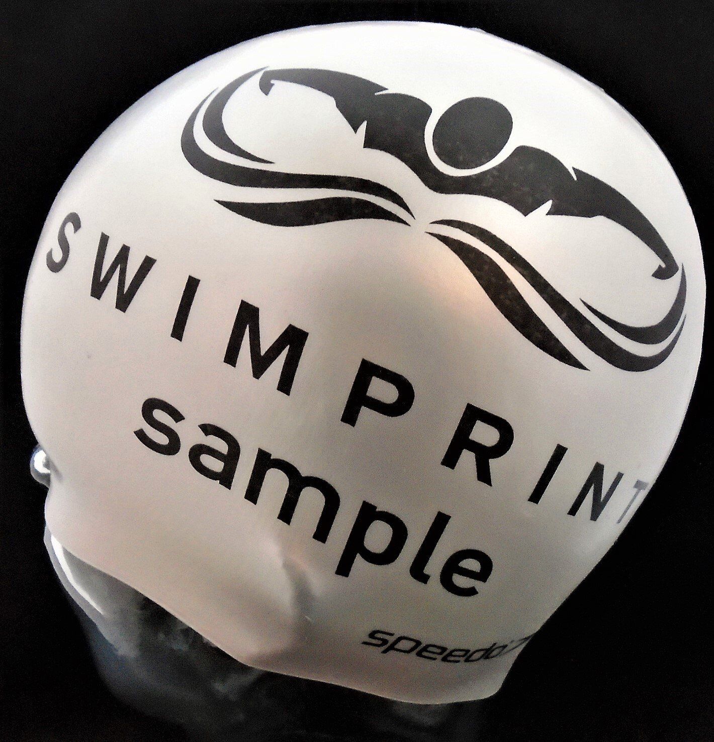 A white swim cap that says swimprint sample on it