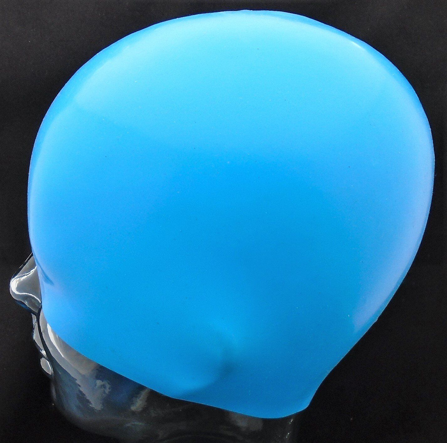 A blue swimming cap is on a mannequin head