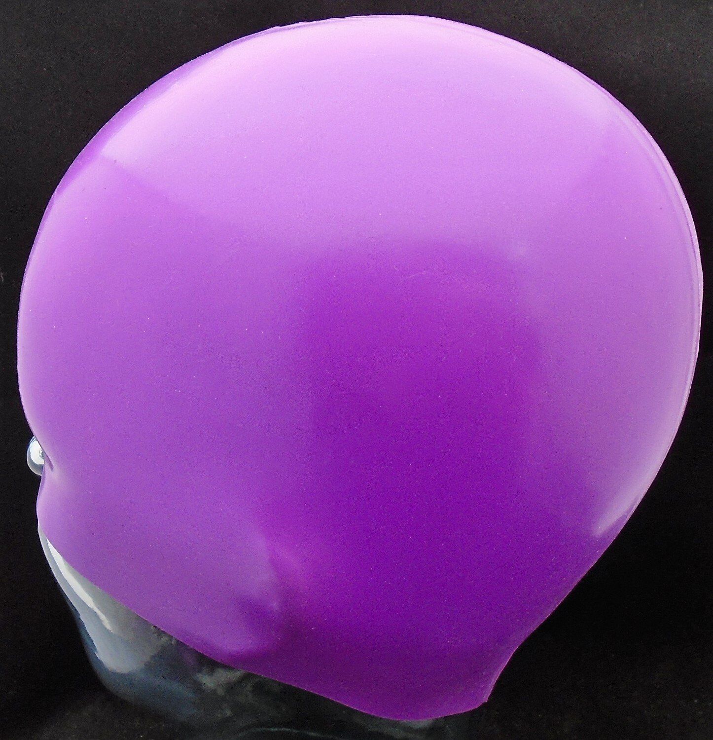 A purple balloon is sitting on a black surface