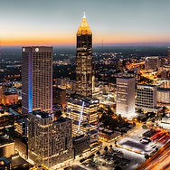 Downtown city skyline at dusk with illuminated skyscrapers and glowing streets