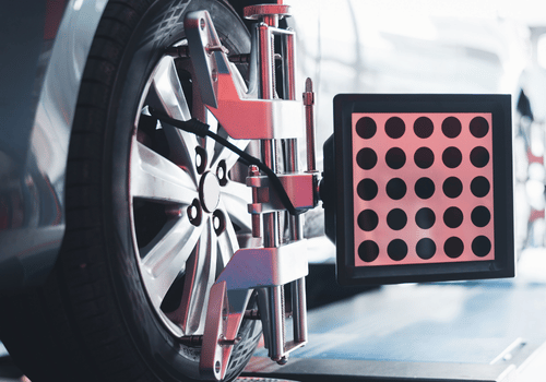 Close-up of a red industrial machine beside a black panel with pink circular sensors