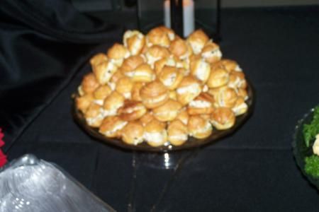 Plate of golden-brown bite-sized pastries on a black tablecloth