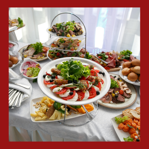Buffet table with assorted seafood, salads, and appetizers on a white tablecloth