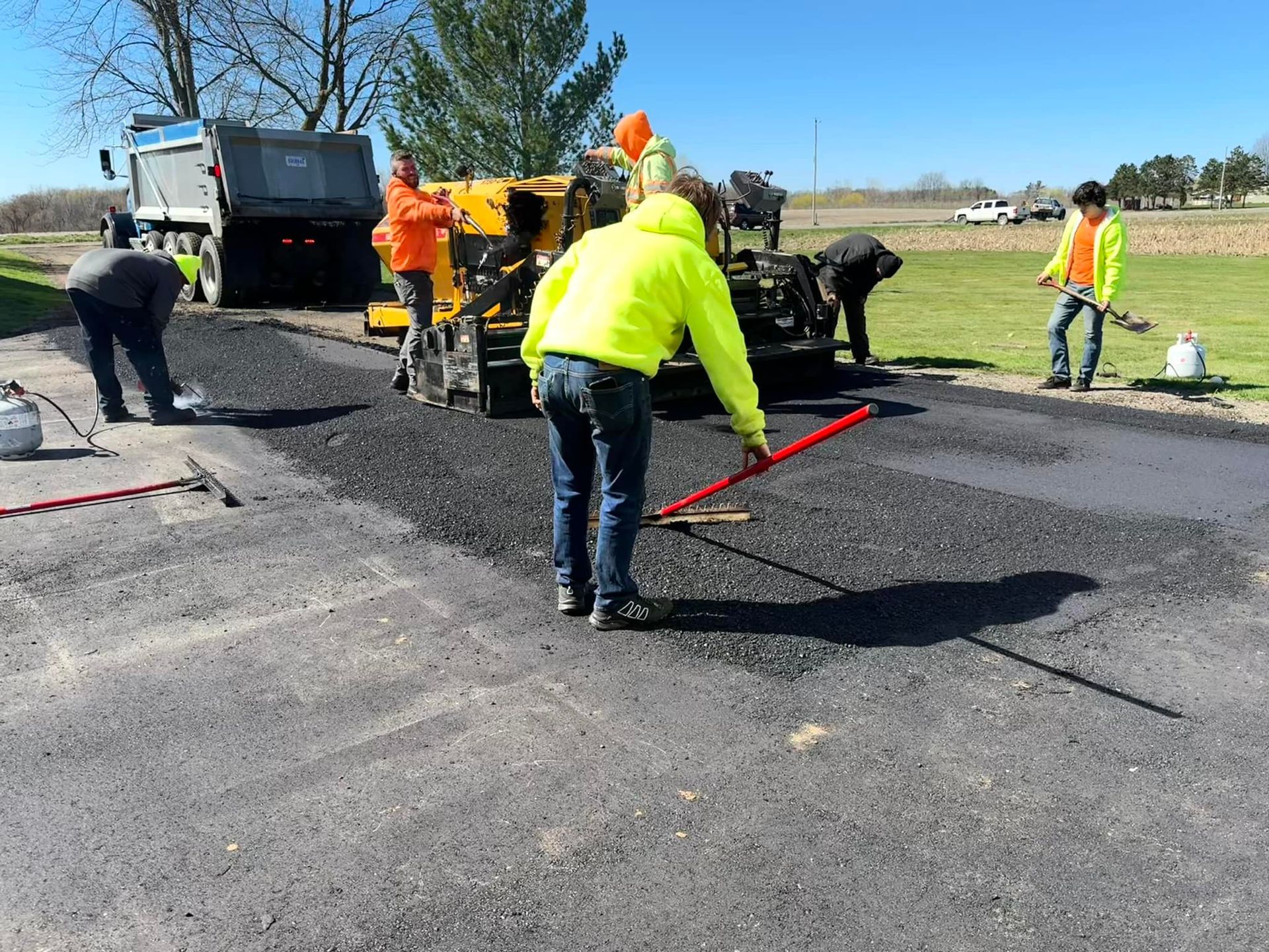 A group of construction workers are working on a road