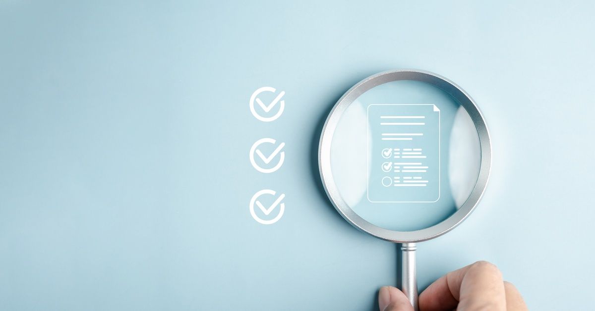 A hand holds a magnifying glass over a document icon. Three checkmark icons are next to the magnifying glass.