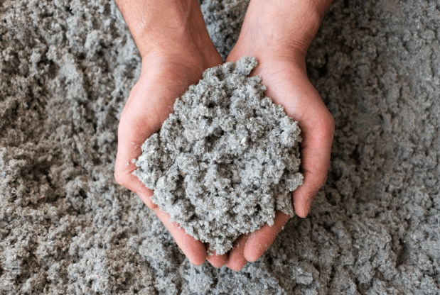 A person is holding a pile of concrete in their hands.