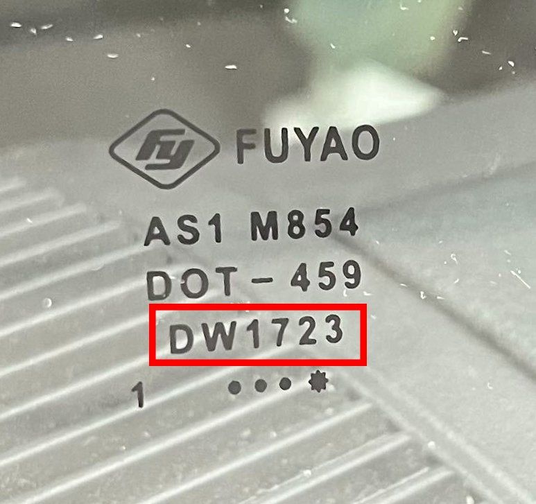 A close-up of a Fuyao brand automotive windshield marking with the product code DW1723 highlighted in a red box.