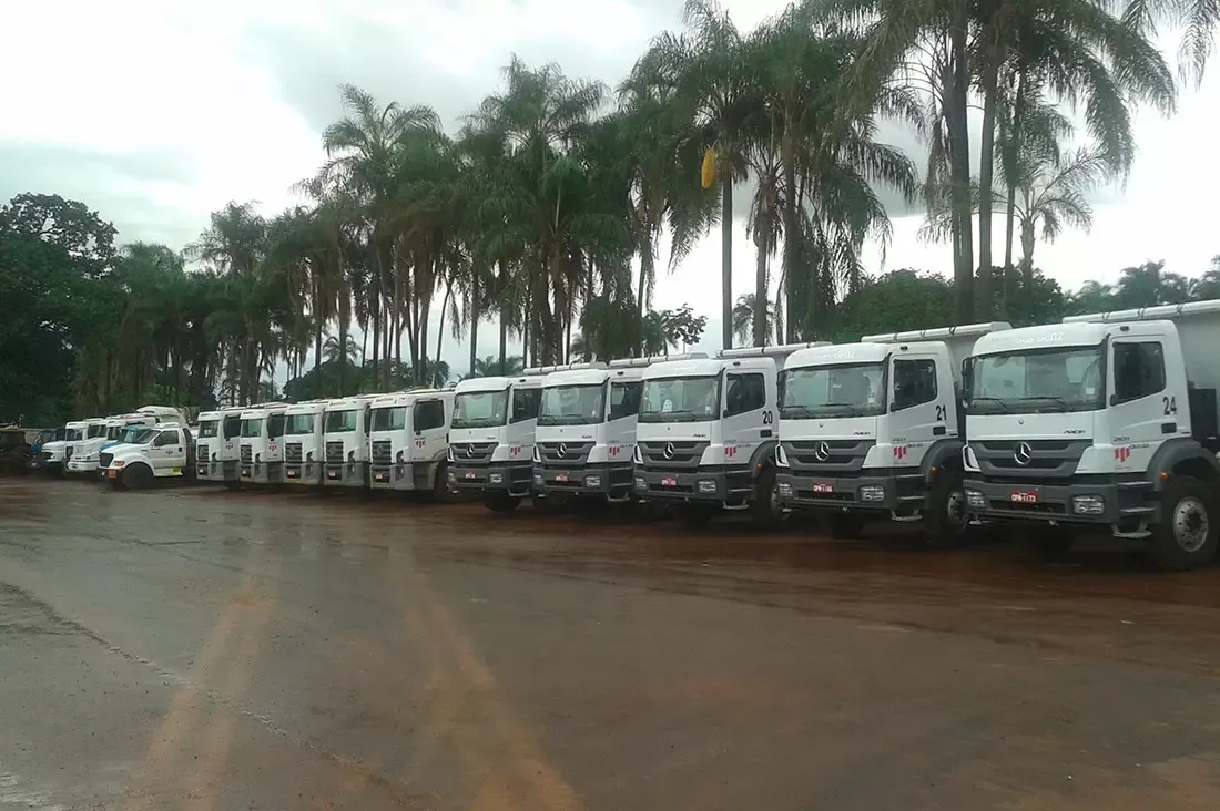 Uma fileira de caminhões está estacionada em um estacionamento.