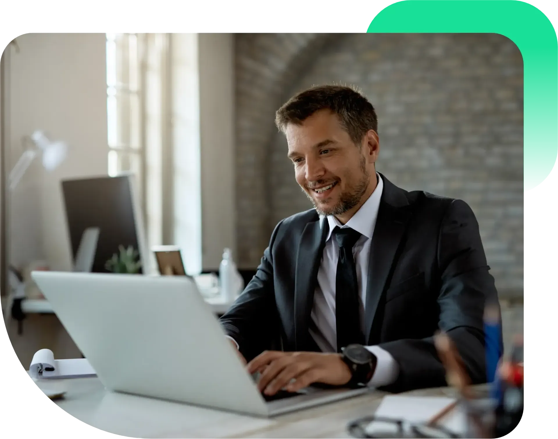 Um homem de terno e gravata está sentado em uma mesa usando um laptop.