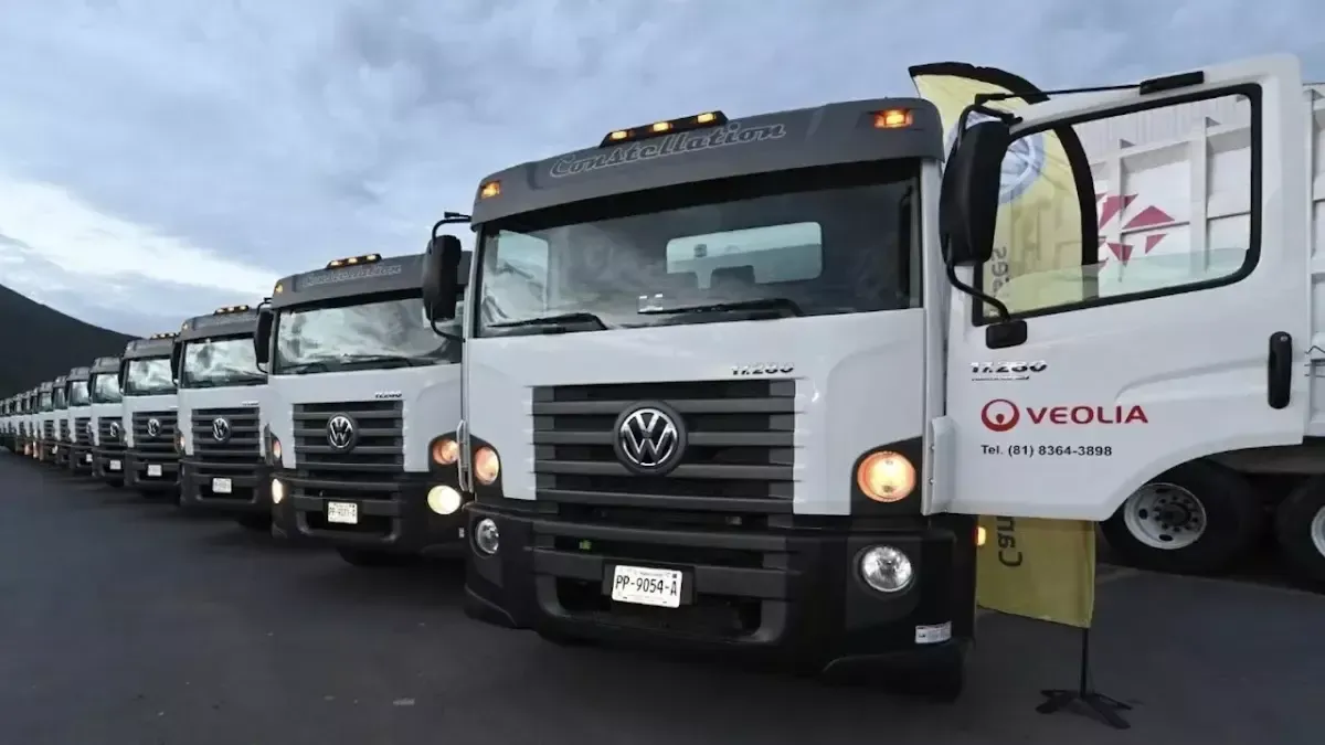 Uma fileira de caminhões estacionados um ao lado do outro em um estacionamento.