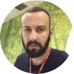 Um homem com barba está usando um cordão em volta do pescoço.
