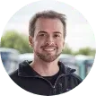 Um homem com barba está sorrindo em um círculo.