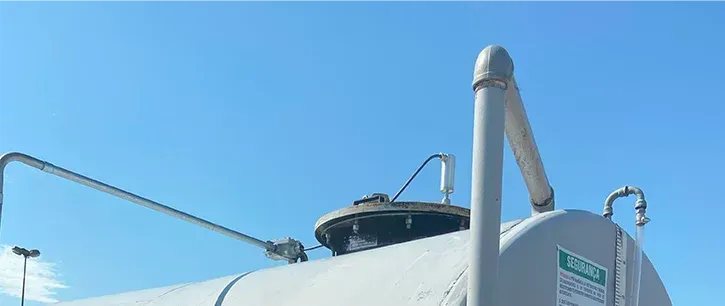 Um grande tanque branco está sentado em frente a um céu azul.