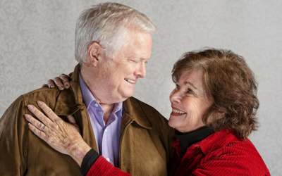 Smiling couple in warm jackets, embracing and looking at each other