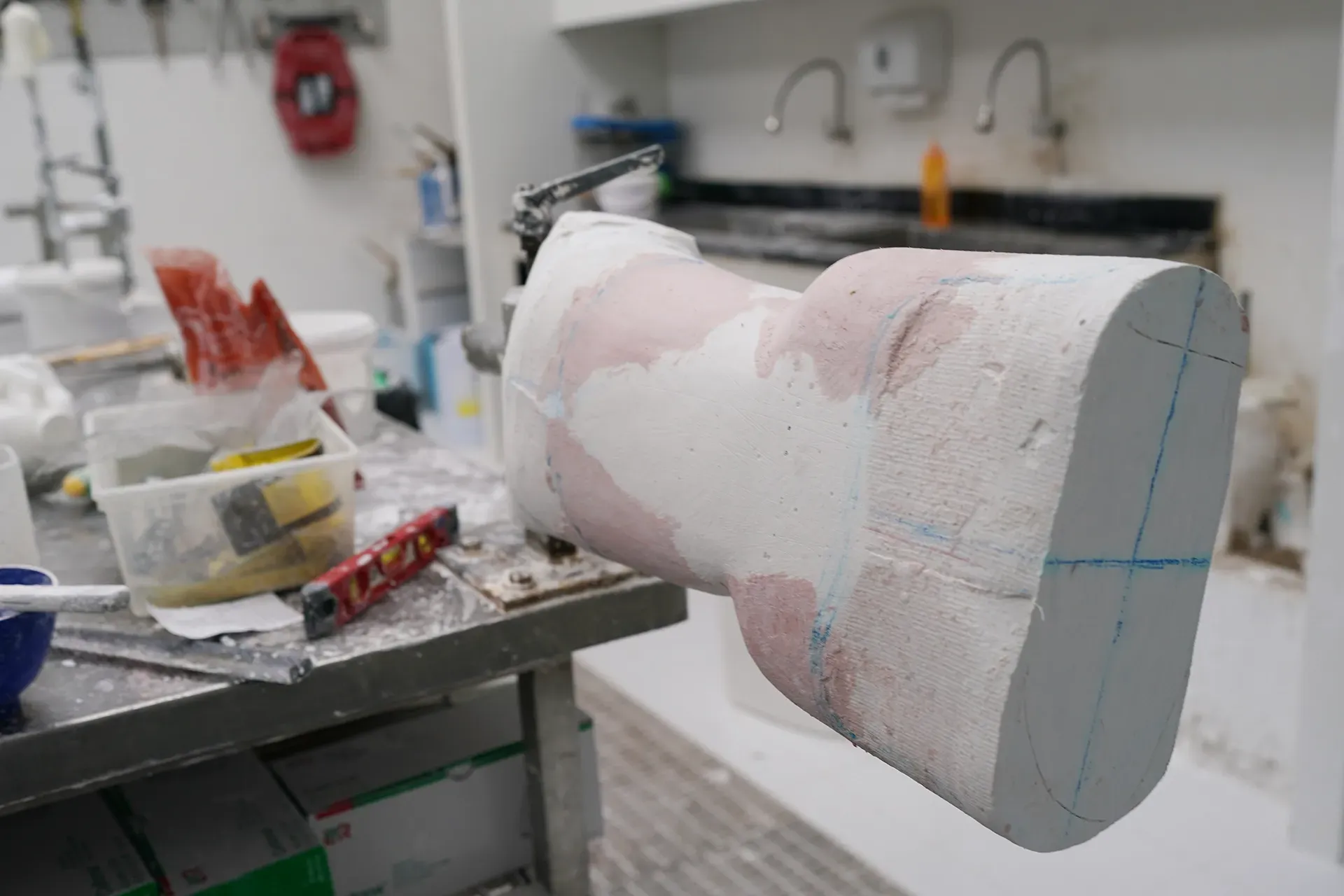 Ein großes Stück weissen Werkstoffs liegt auf einem Metalltisch.