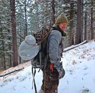 A man with a backpack is standing in the snow