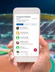 Hand holding a smartphone showing a volleyball team roster app on a stadium background