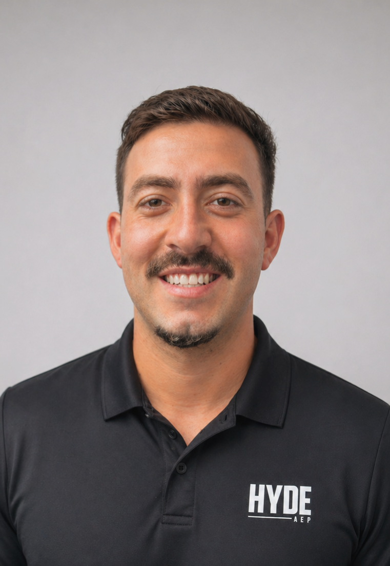 Smiling man in a black HYDE polo shirt against a light gray background