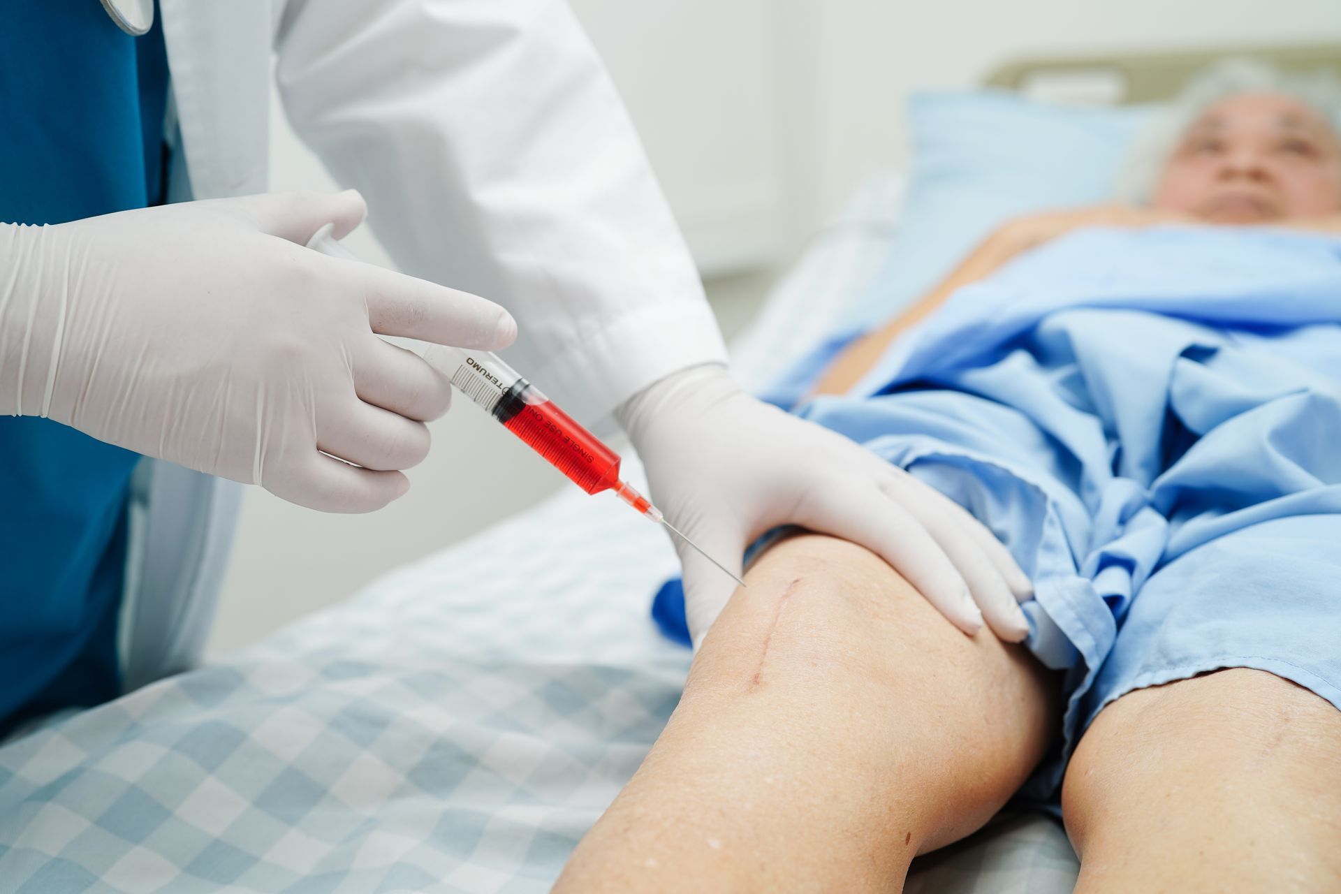 A doctor is giving a patient an injection in their leg.