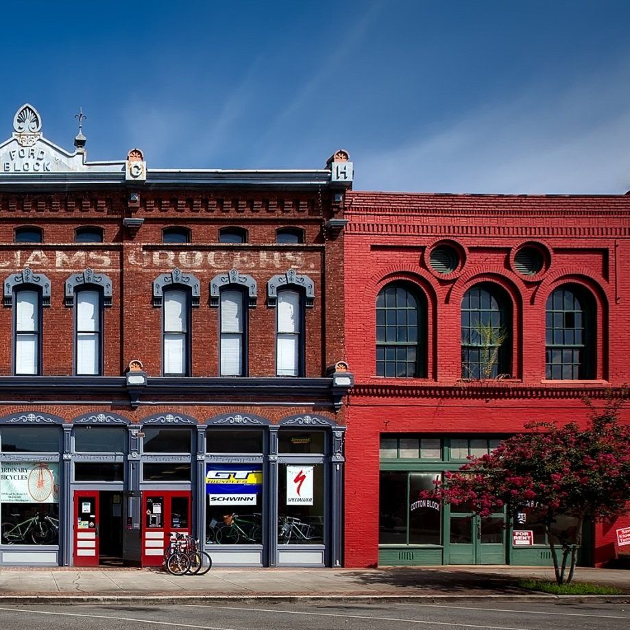 Two story commercial brick buildings with windows and signs