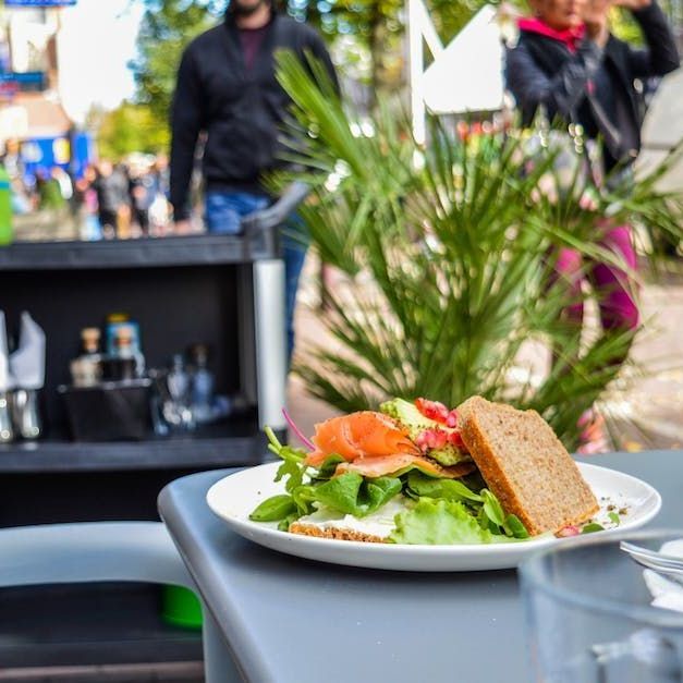 A plate of food with a sandwich on it is on a table.