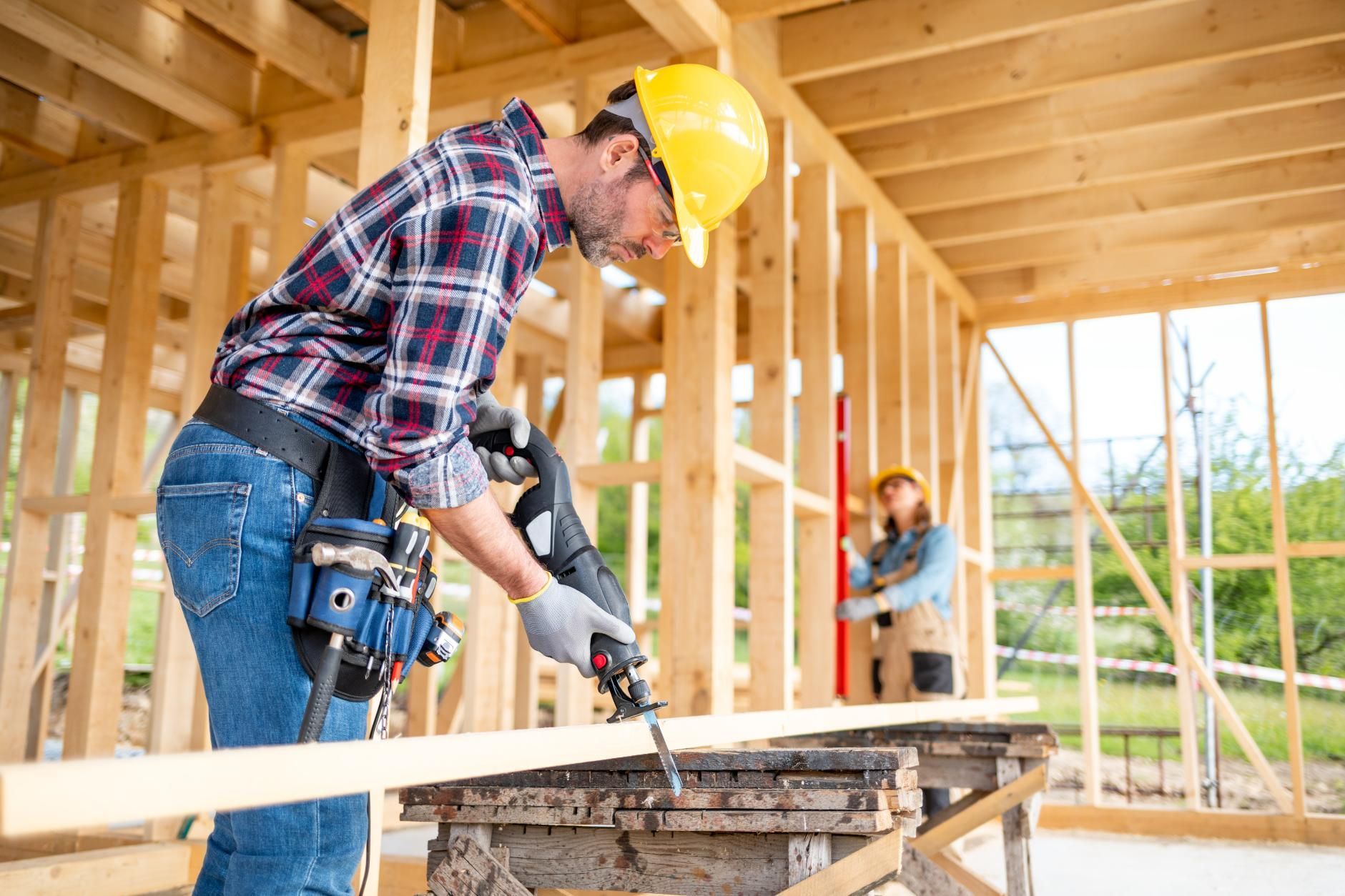 A man is using a drill to cut a piece of wood.