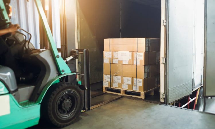 Forklift loading palletized freight onto temperature-controlled truck at shipping dock.