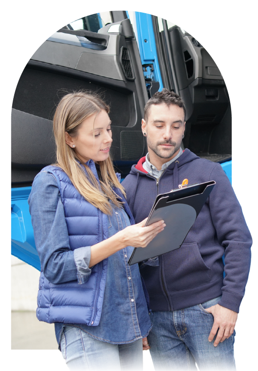 Logistics team reviewing refrigerated freight paperwork beside temperature-controlled truck.