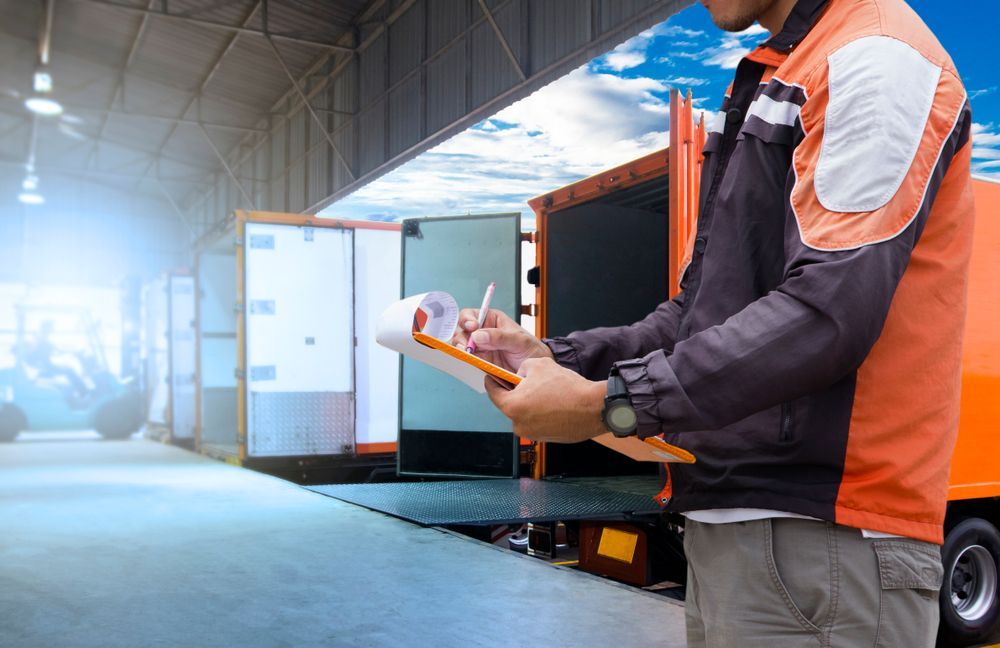 Warehouse Logistics and transportation, Worker holding clipboard is control loading cargo courier shipment, truck docking at warehouse