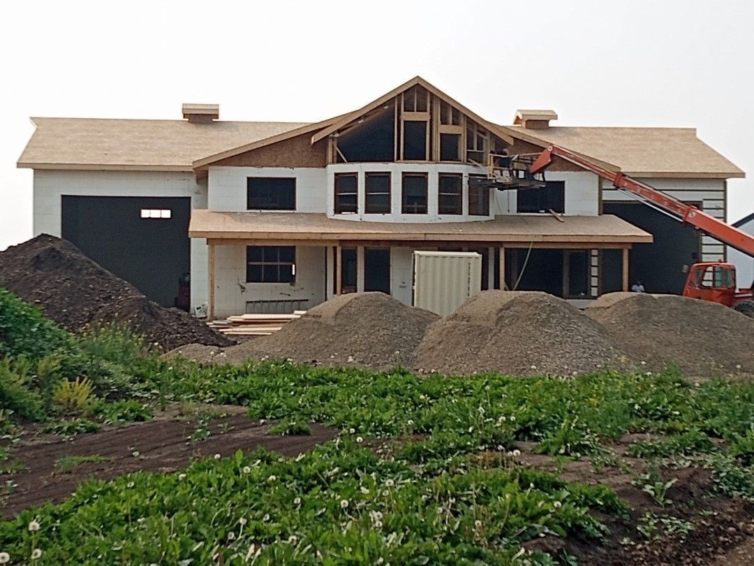 A large house is being built in the middle of a field