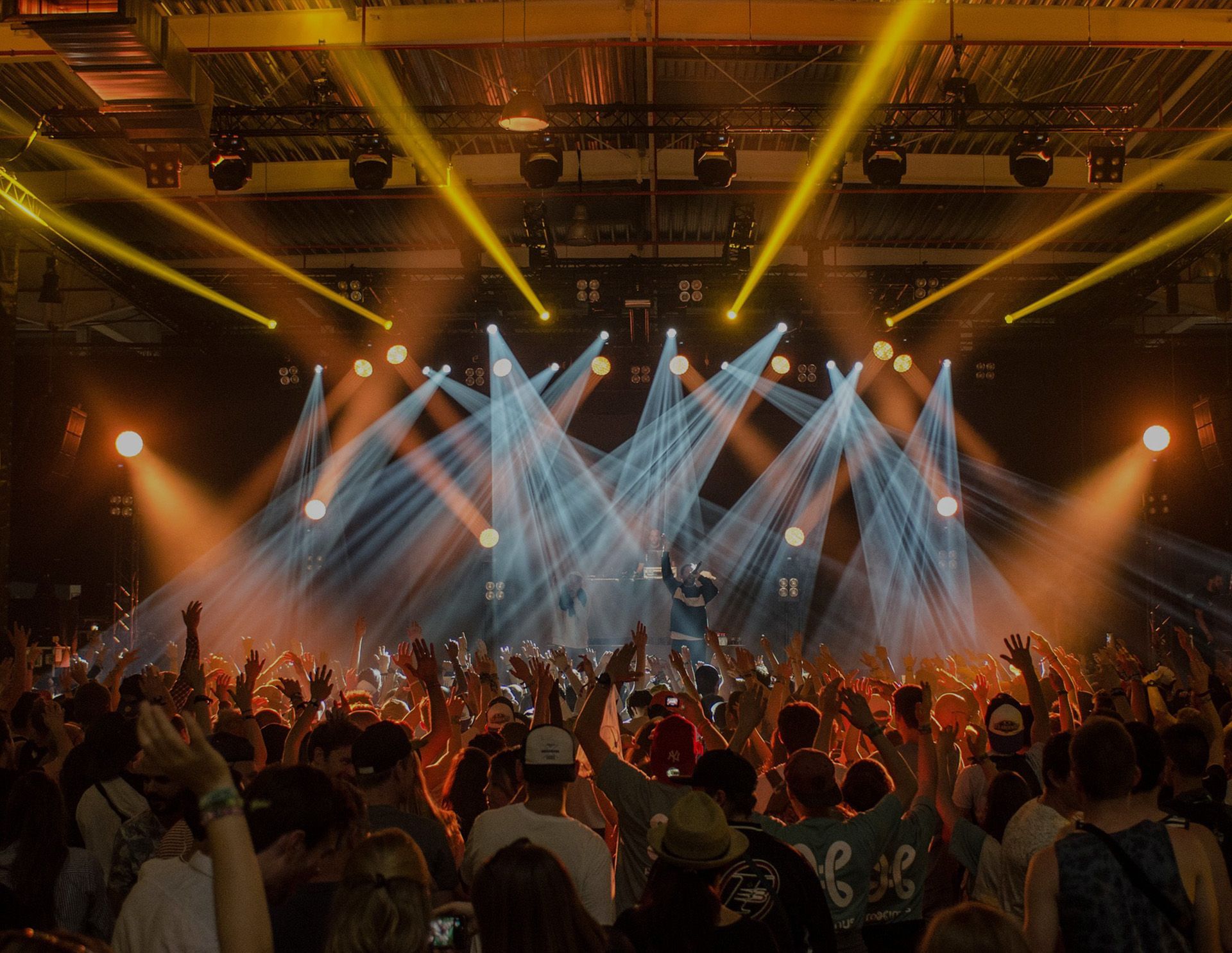A crowd of people are standing in front of a stage at a concert.