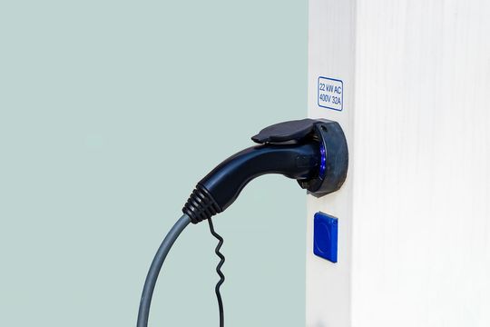 an electric car plugged into a white wall