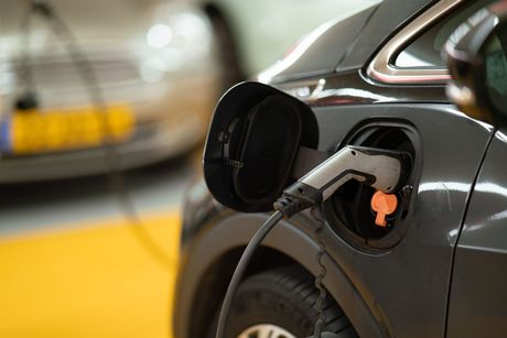 a row of electric cars plugged in to a wall
