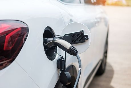 a white car with an electric charger attached to it