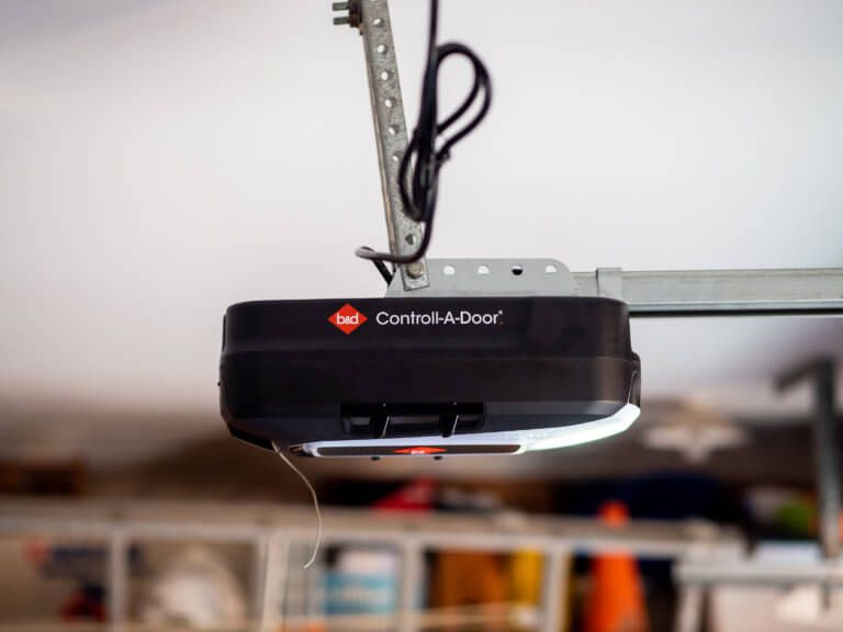 Black Chamberlain garage door opener mounted on a ceiling rail indoors