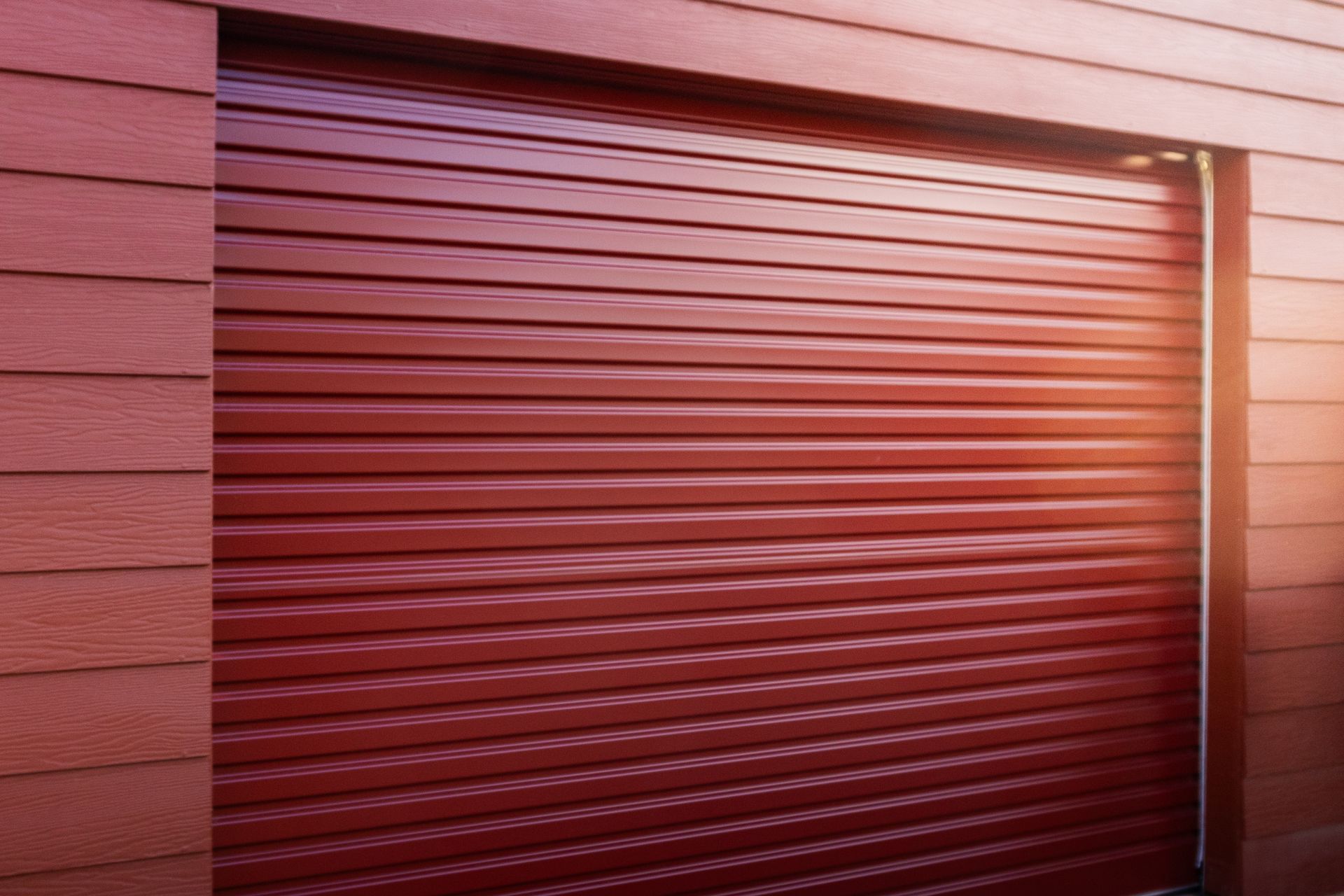 Closed gray metal roll-up garage door on a brick building facade