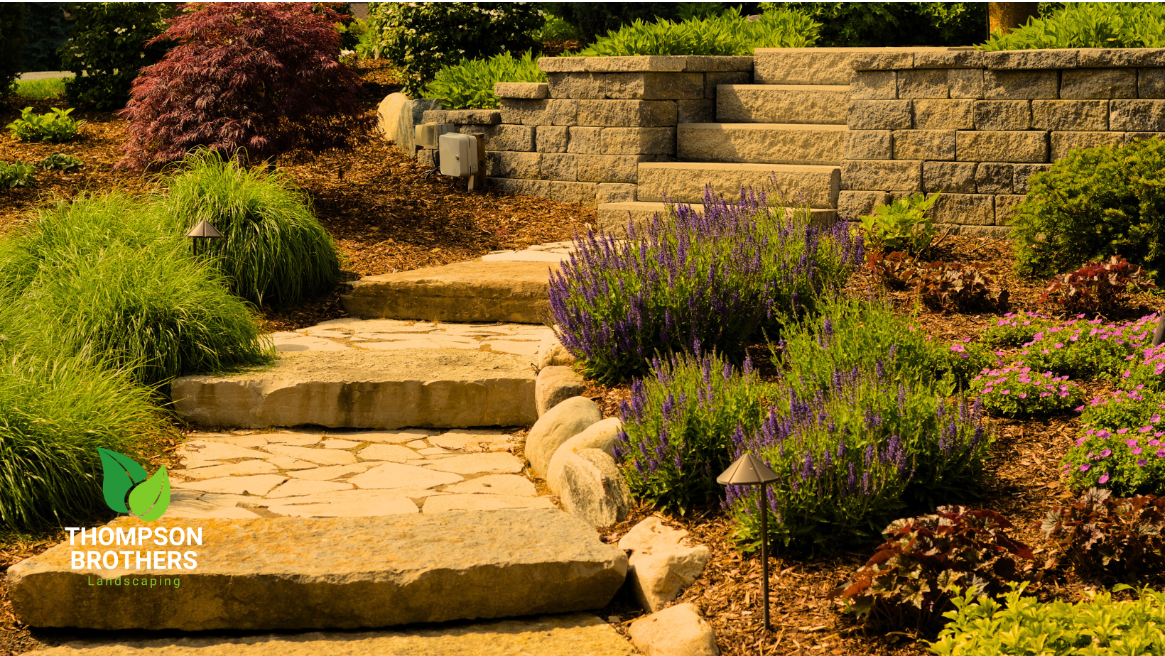 Stone steps ascend through a landscaped garden with various plants and a retaining wall.