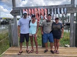 A group of people are posing for a picture on a dock.