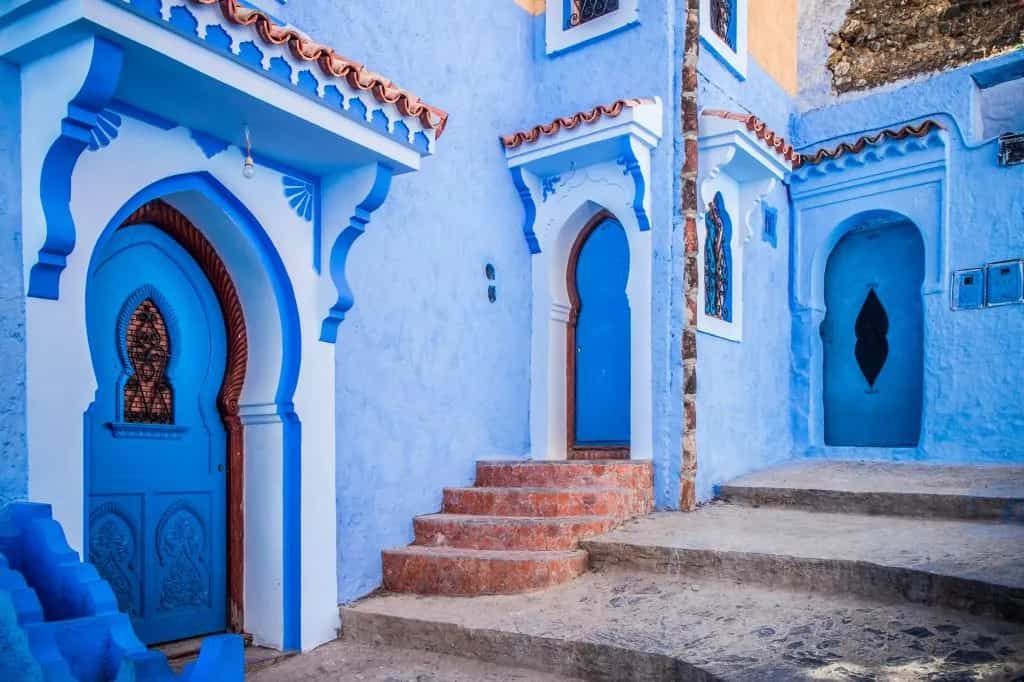 A blue and white building with blue doors and stairs.