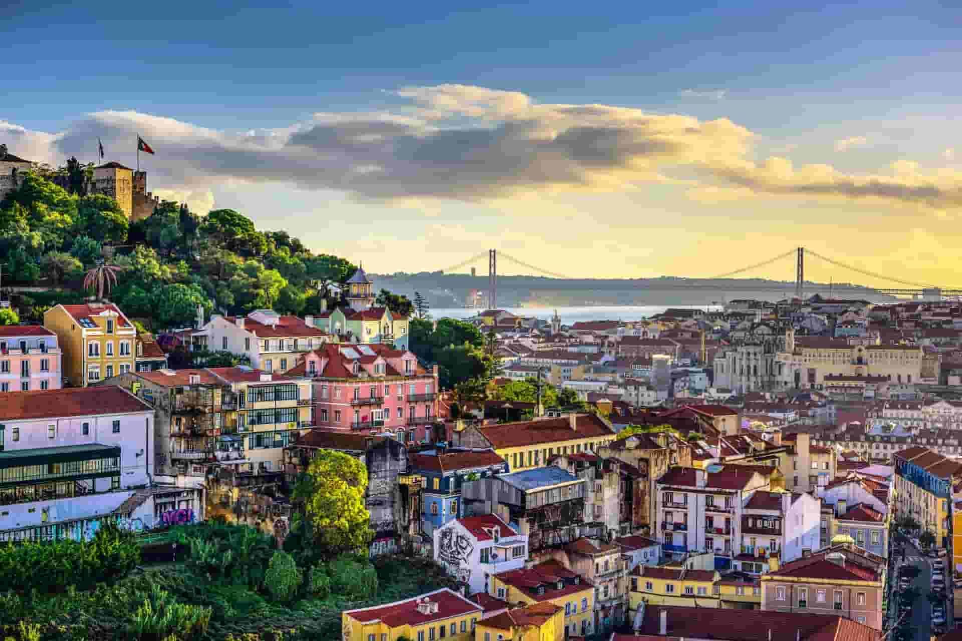 An aerial view of Lisbon with a bridge in the background.