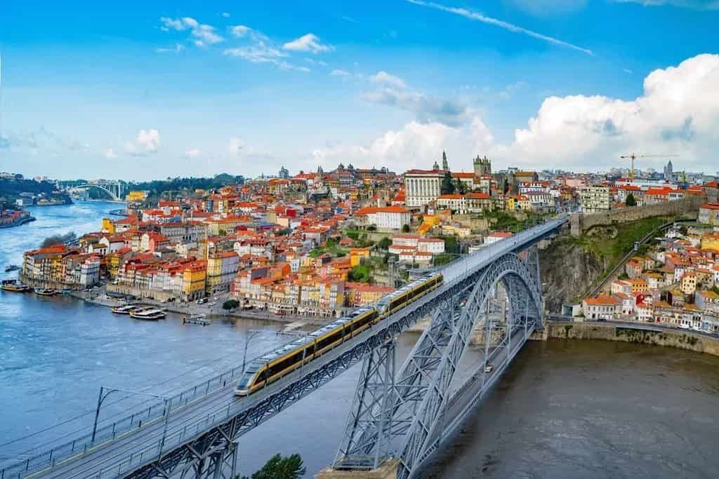 An aerial view of Porto with a bridge in the background.