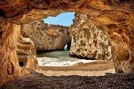 A view of a beach from inside a cave.