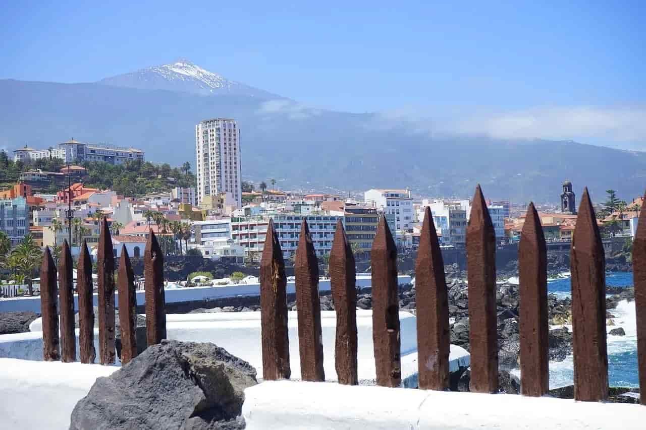A fence with tenerife in the background and a mountain in the background
