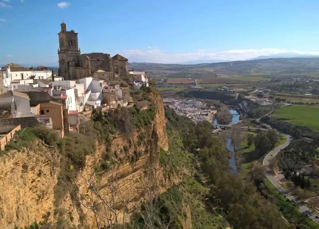 An aerial view of Arcos on a cliff overlooking a river.